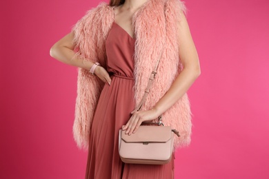 Young woman with stylish bag on pink background, closeup