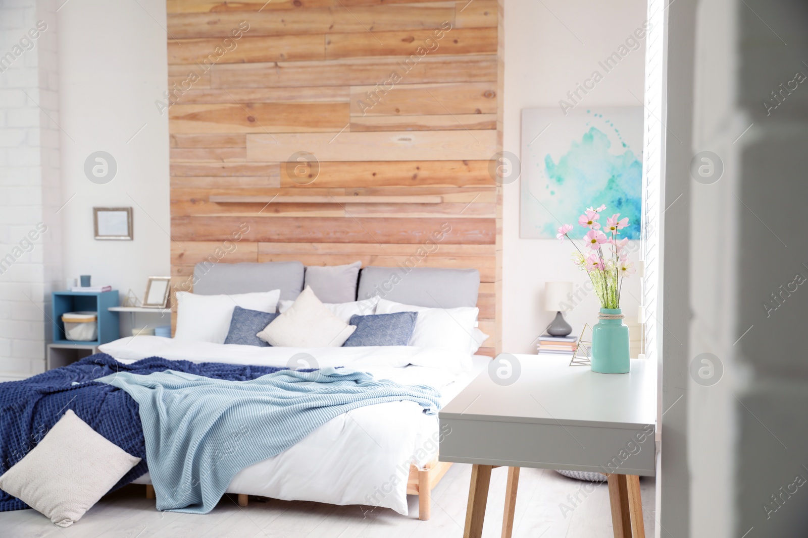 Photo of Fresh flowers on table in stylish bedroom interior