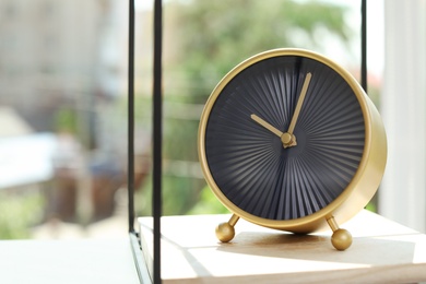 Photo of Analog alarm clock on table. Time of day