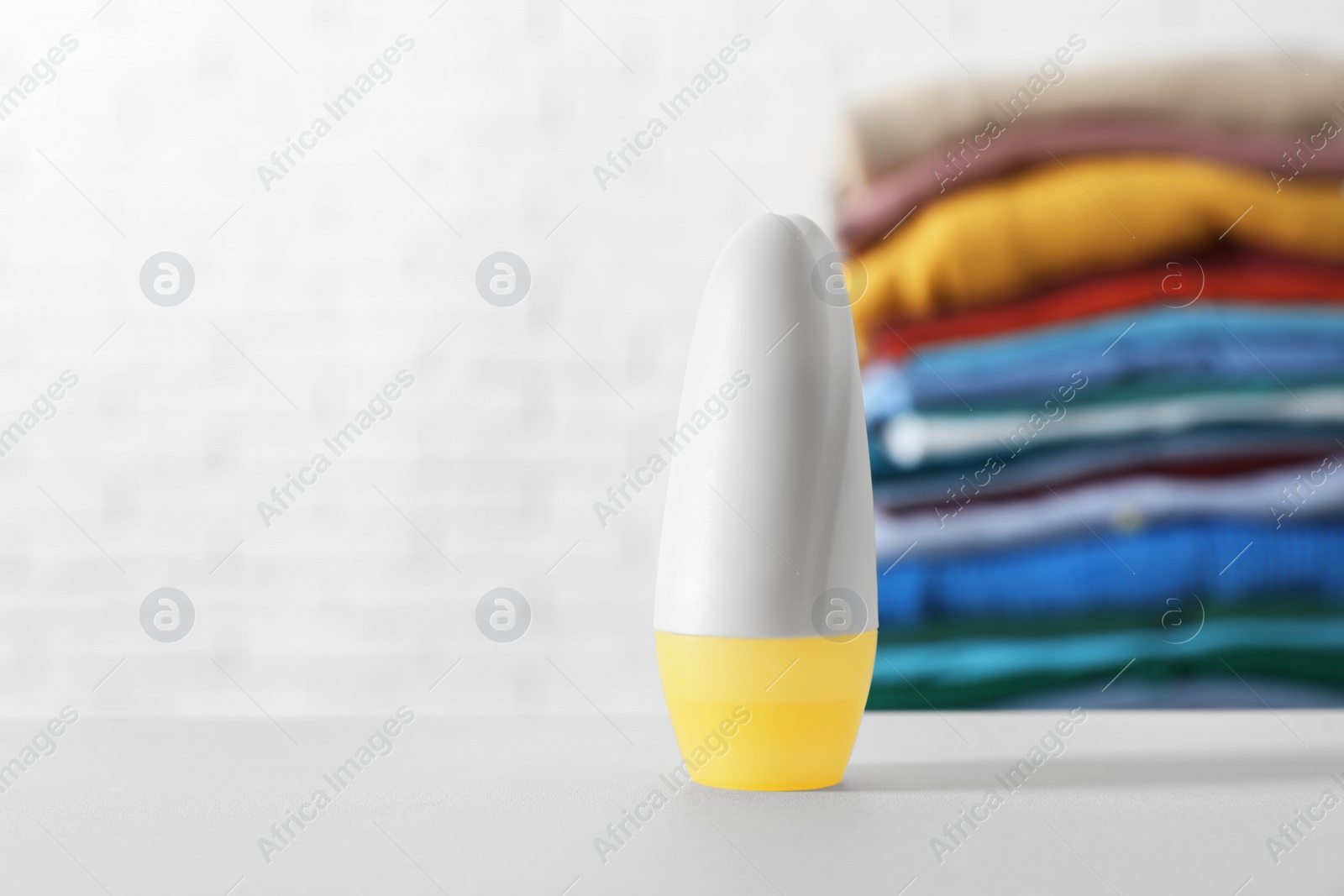 Photo of Roll-on deodorant on white table. Space for text