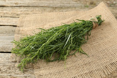Photo of Bunch of fresh tarragon on wooden table