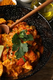 Photo of Delicious chicken curry in frying pan on table
