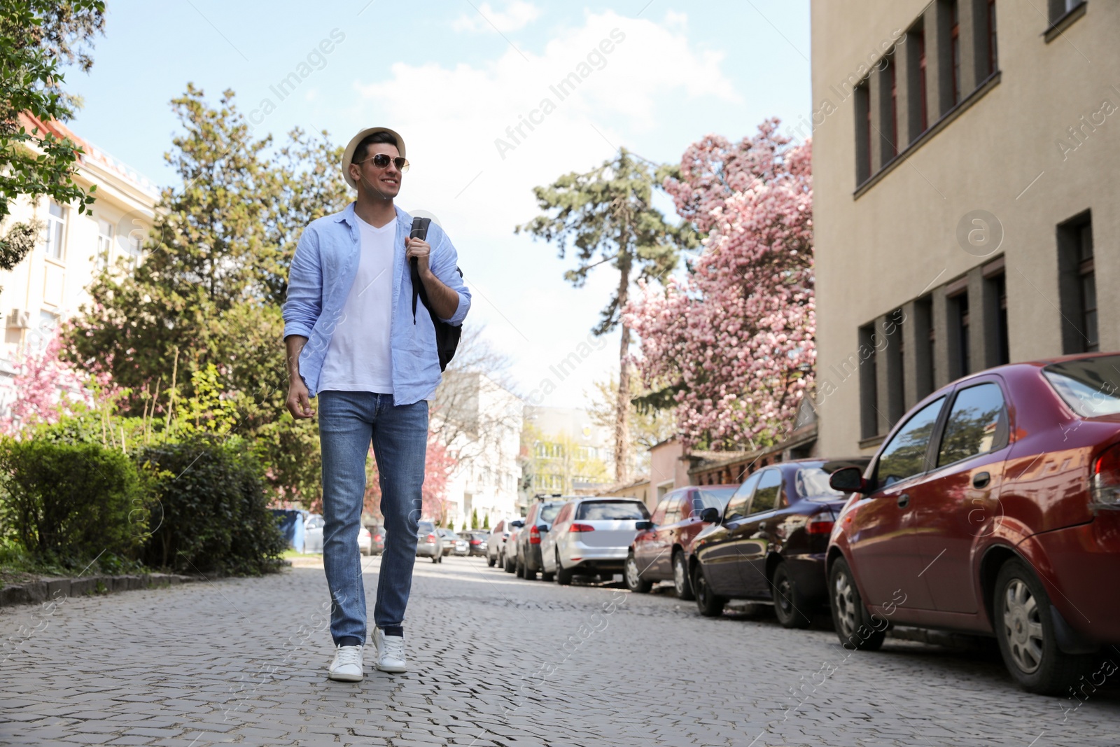 Photo of Tourist with backpack walking on city street