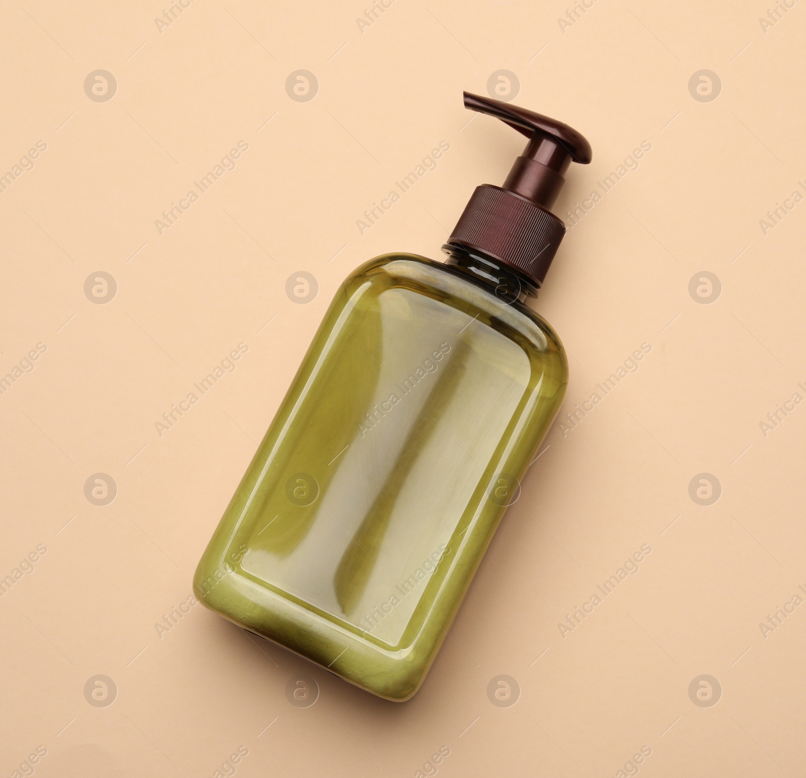 Photo of Bottle of shampoo on beige background, top view