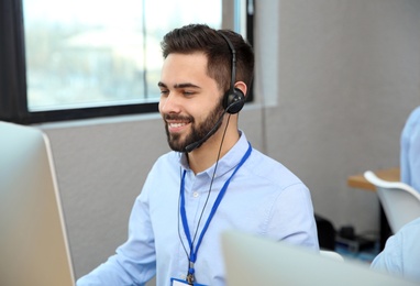Photo of Technical support operator with headset working in office