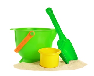 Photo of Plastic beach toys on pile of sand against white background