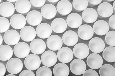 Many styrofoam cups on light grey background, flat lay