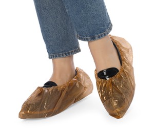 Woman wearing shoe covers onto her shoes against white background, closeup