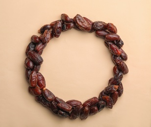 Photo of Frame made of sweet dried date fruits on color background, top view with space for text