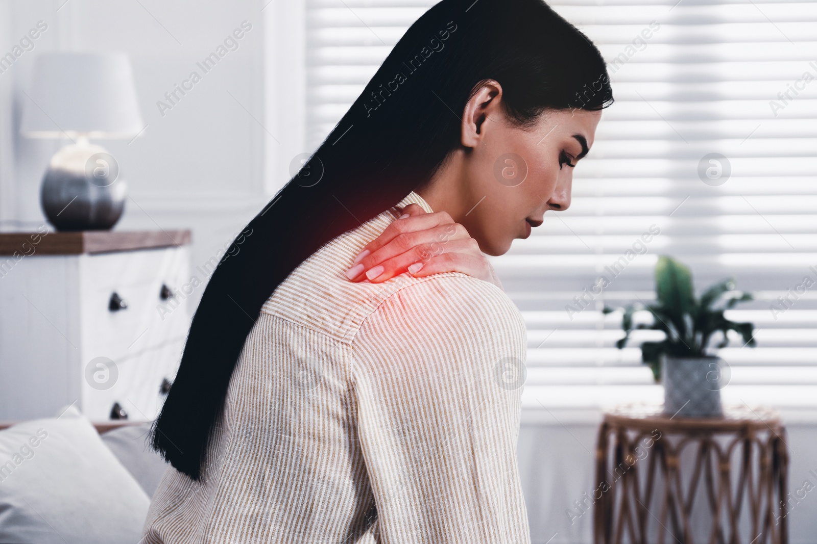 Image of Woman suffering from shoulder pain at home