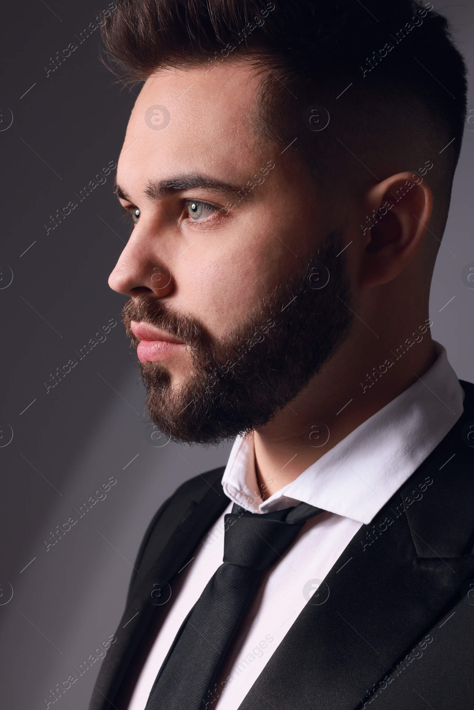 Photo of Handsome bearded man in stylish suit on grey background