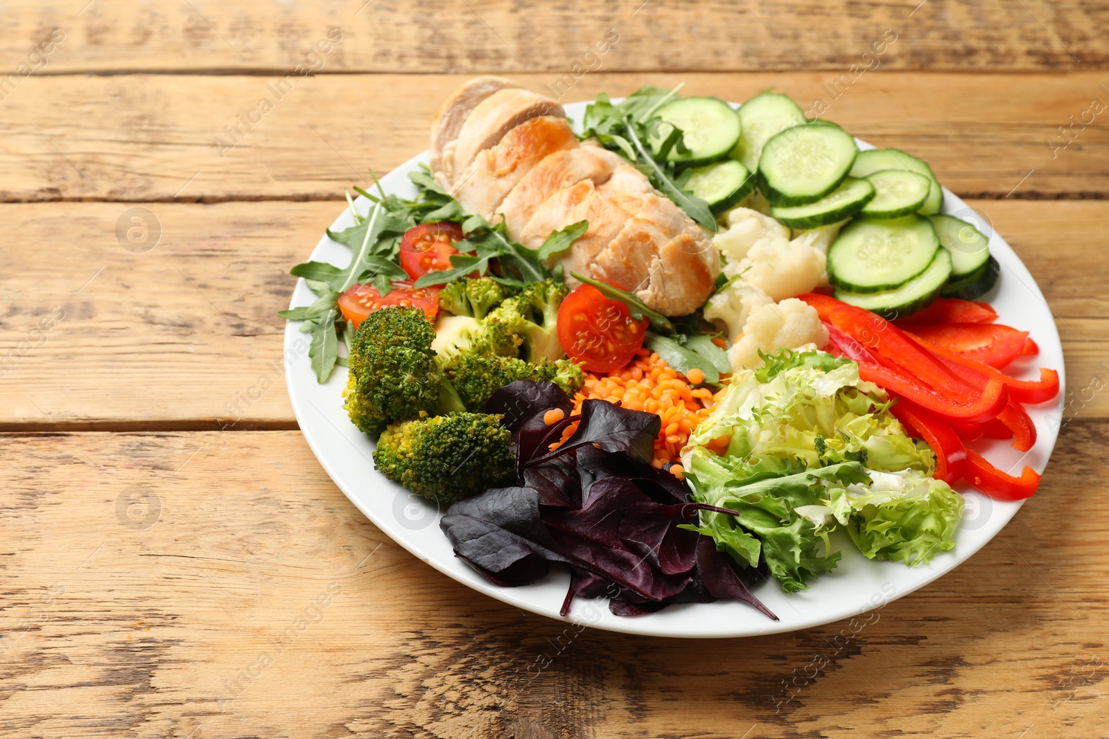 Photo of Balanced diet and healthy foods. Plate with different delicious products on wooden table. Space for text