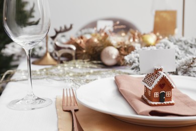 Photo of Luxury festive place setting with blank card and beautiful decor for Christmas dinner on white table indoors, closeup