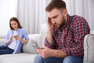 Photo of Couple addicted to smartphones at home. Relationship problems