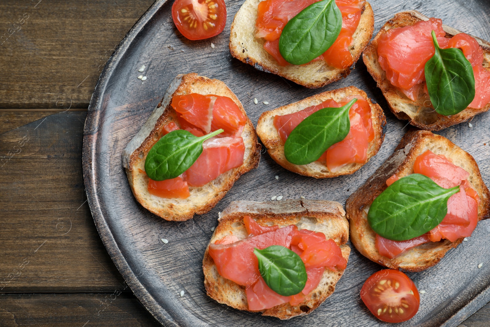 Photo of Delicious sandwiches with salmon and spinach on wooden table, top view