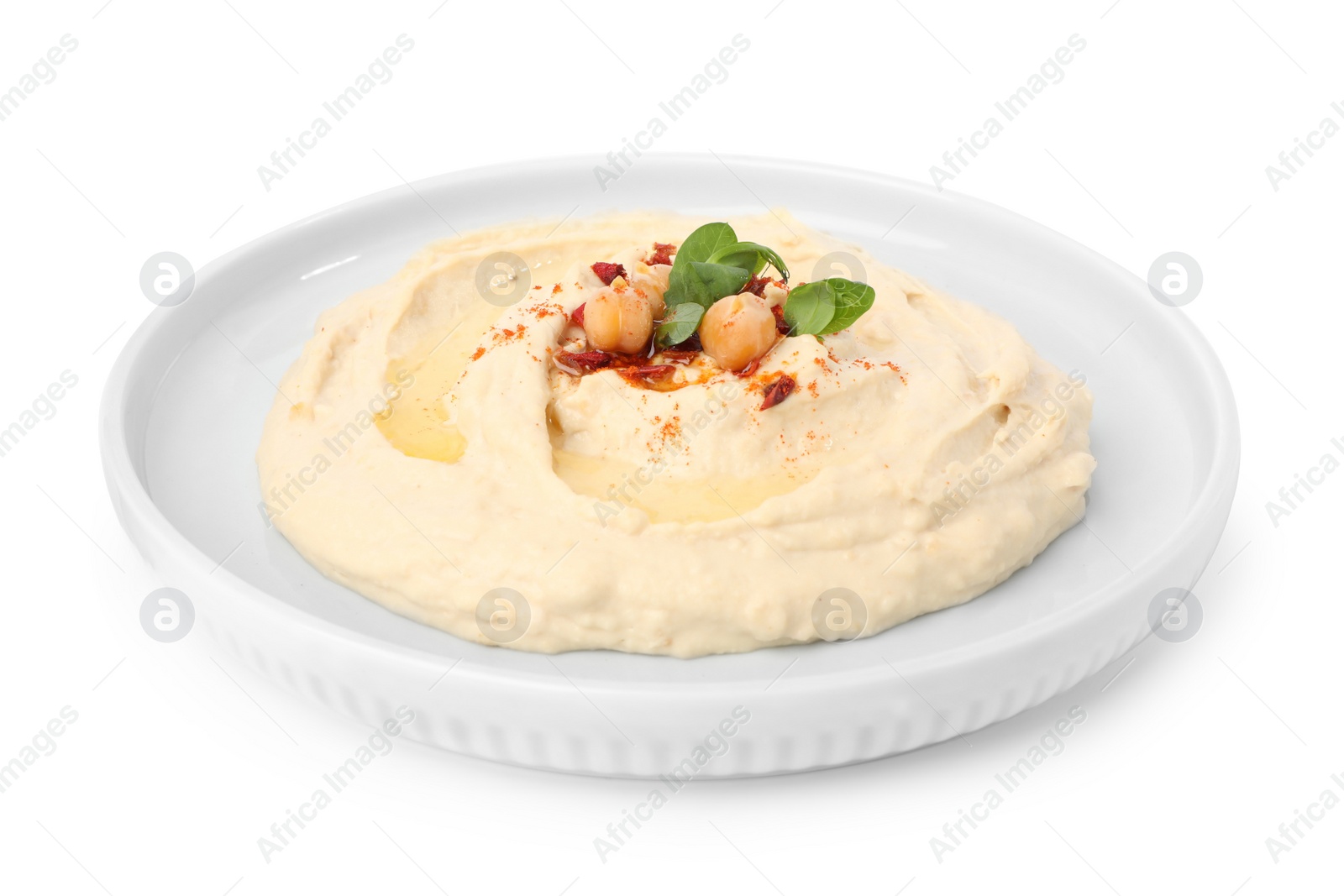 Photo of Plate of tasty hummus with garnish isolated on white
