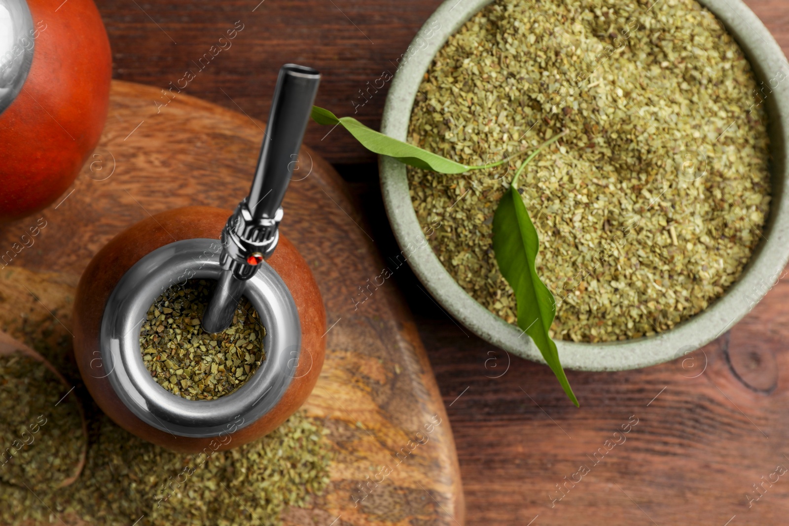 Photo of Calabash with mate tea and bombilla on wooden table, flat lay