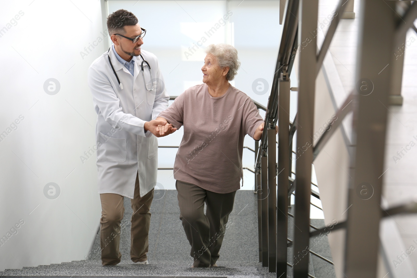 Photo of Doctor helping senior patient in modern hospital