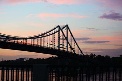 Photo of KYIV, UKRAINE - MAY 23, 2019: Beautiful view of pedestrian bridge over Dnipro river in evening