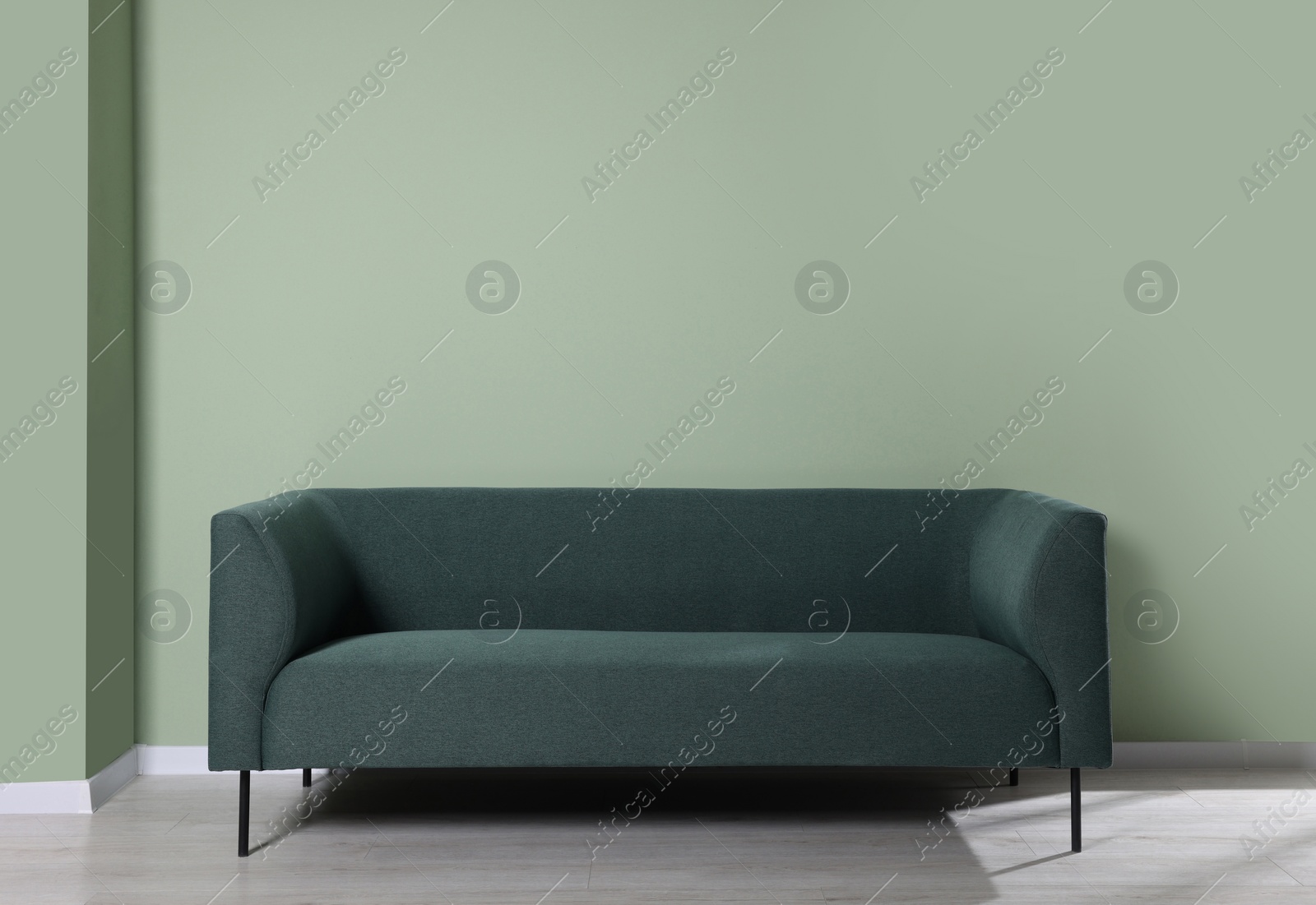 Photo of Comfortable sofa near light green wall indoors