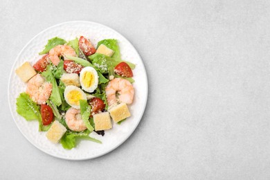 Photo of Delicious Caesar salad with shrimps on light table, top view. Space for text