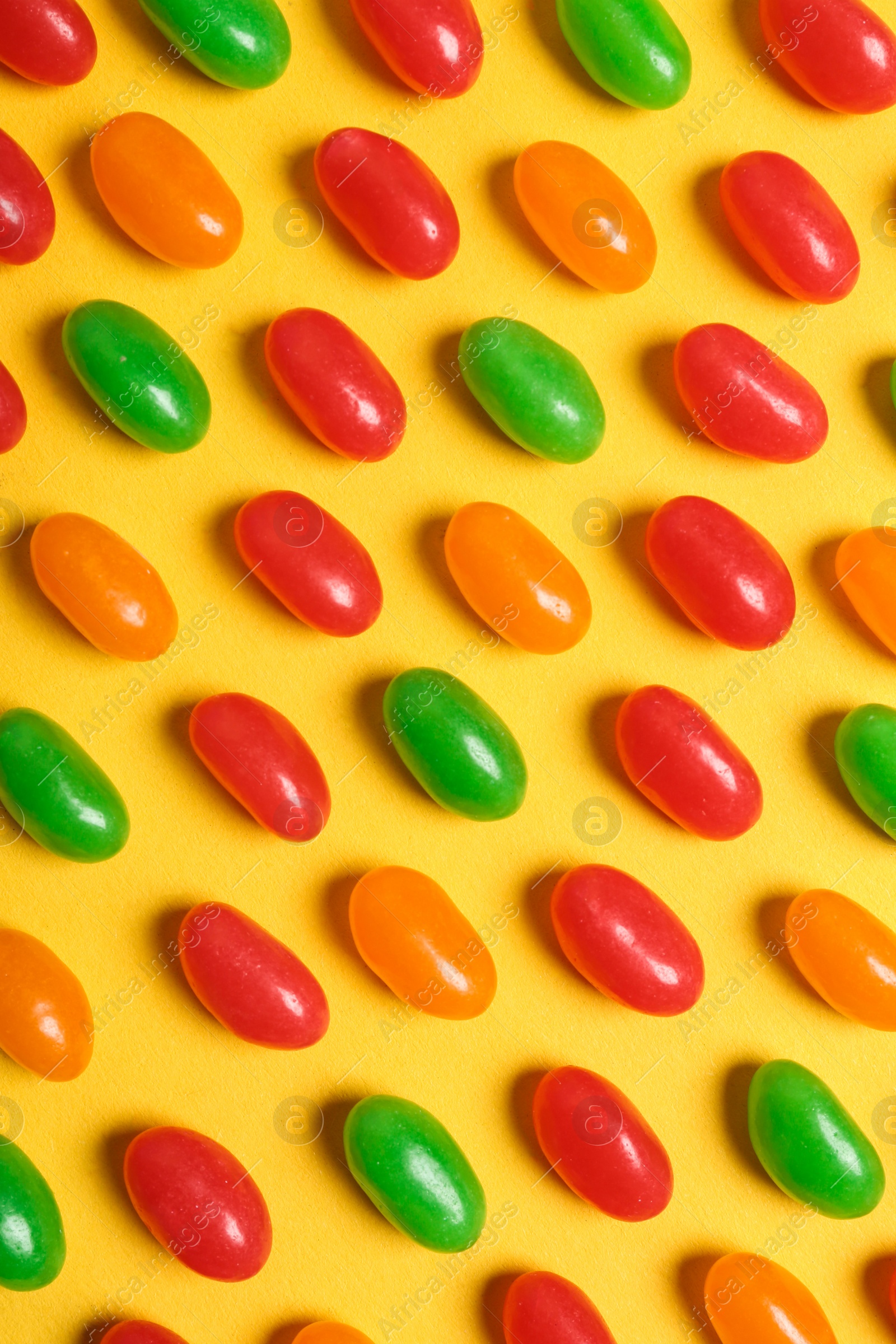 Photo of Flat lay composition with delicious jelly beans on color background