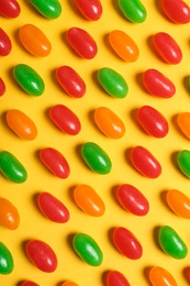 Flat lay composition with delicious jelly beans on color background