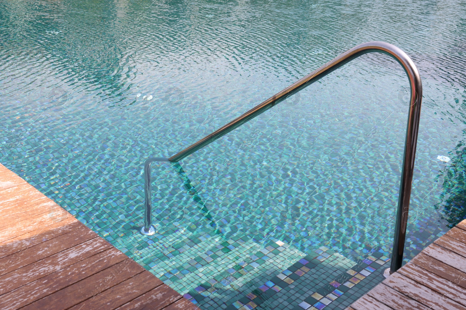 Photo of Metal rail and steps in outdoor swimming pool