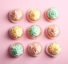 Photo of Flat lay composition with delicious cupcakes on color background