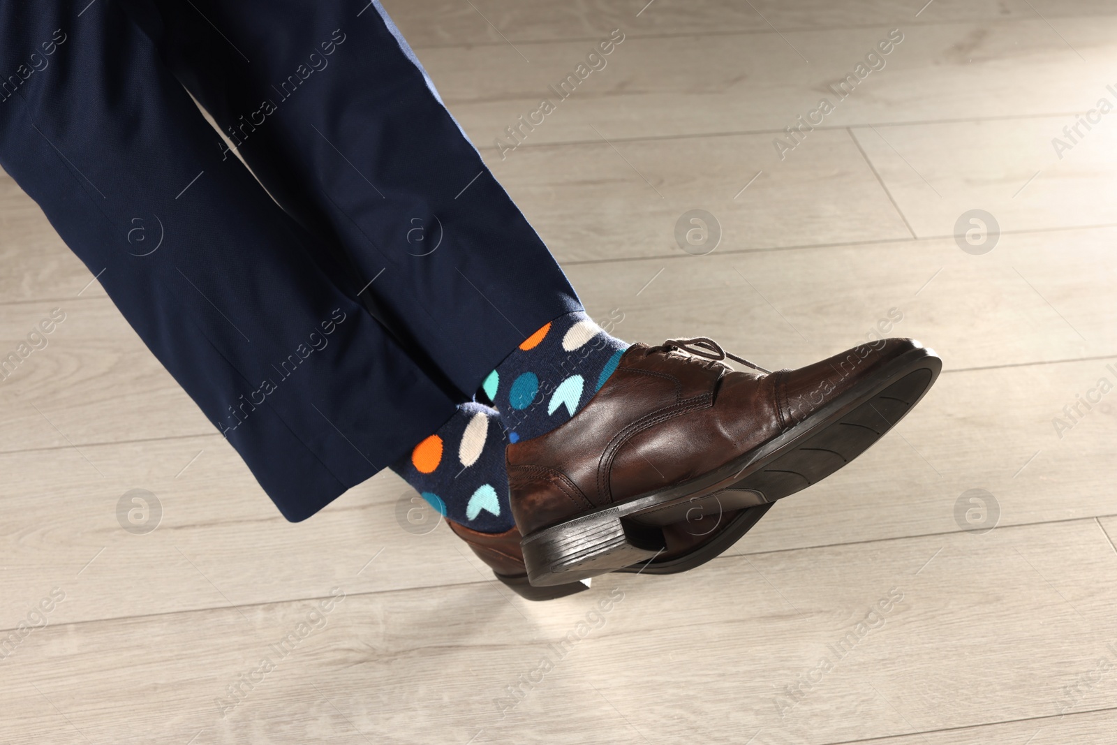 Photo of Man wearing stylish shoes and colorful socks indoors, closeup