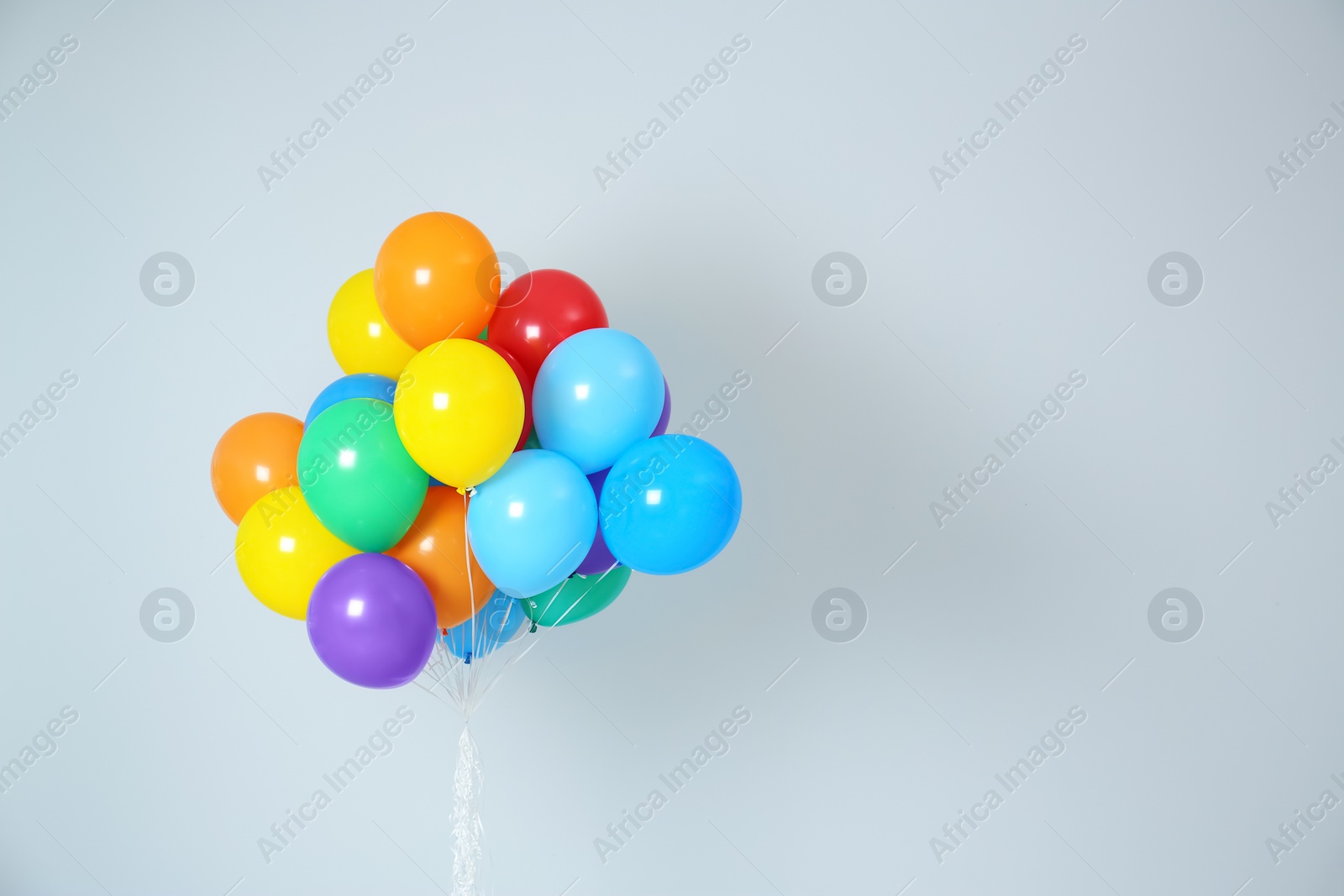 Photo of Bunch of bright balloons and space for text against white background