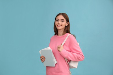 Teenage student with books and backpack on turquoise background