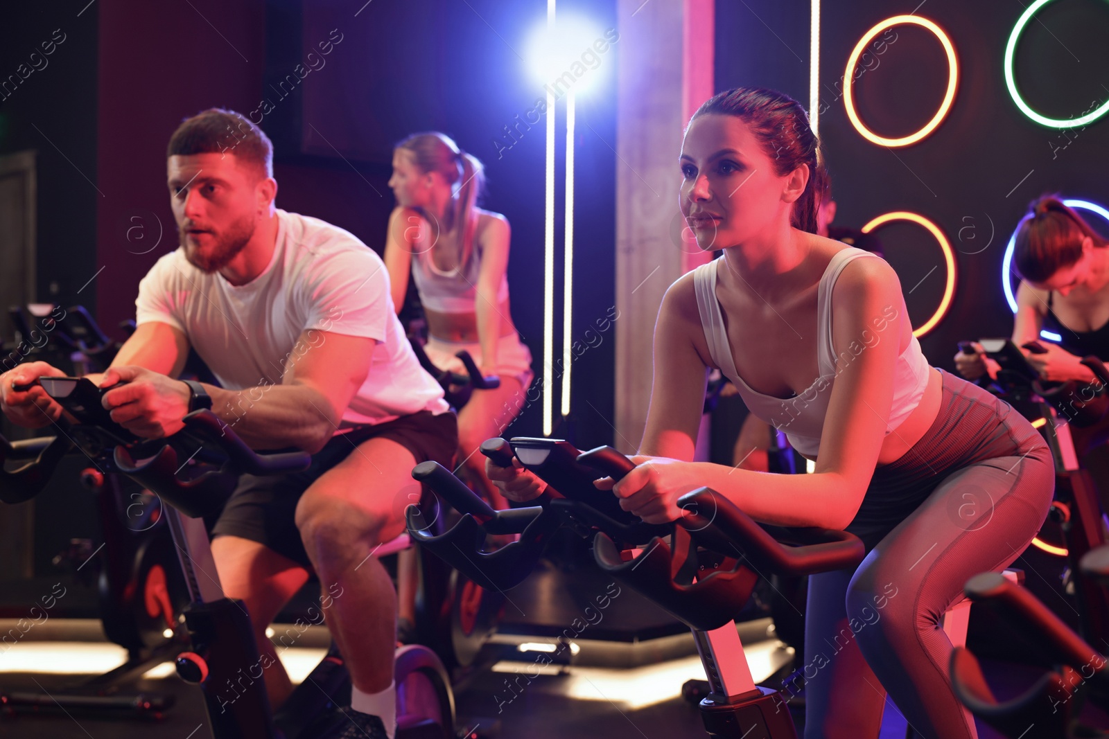 Photo of Group of people training on exercise bikes in fitness club