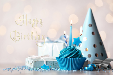 Image of Delicious cupcake with burning candles and text Happy birthday on blurred background