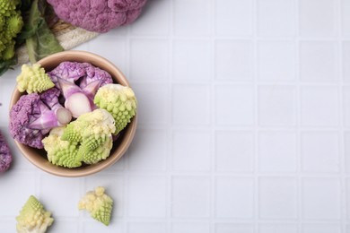 Various cauliflower cabbages on white tiled table, flat lay. Space for text