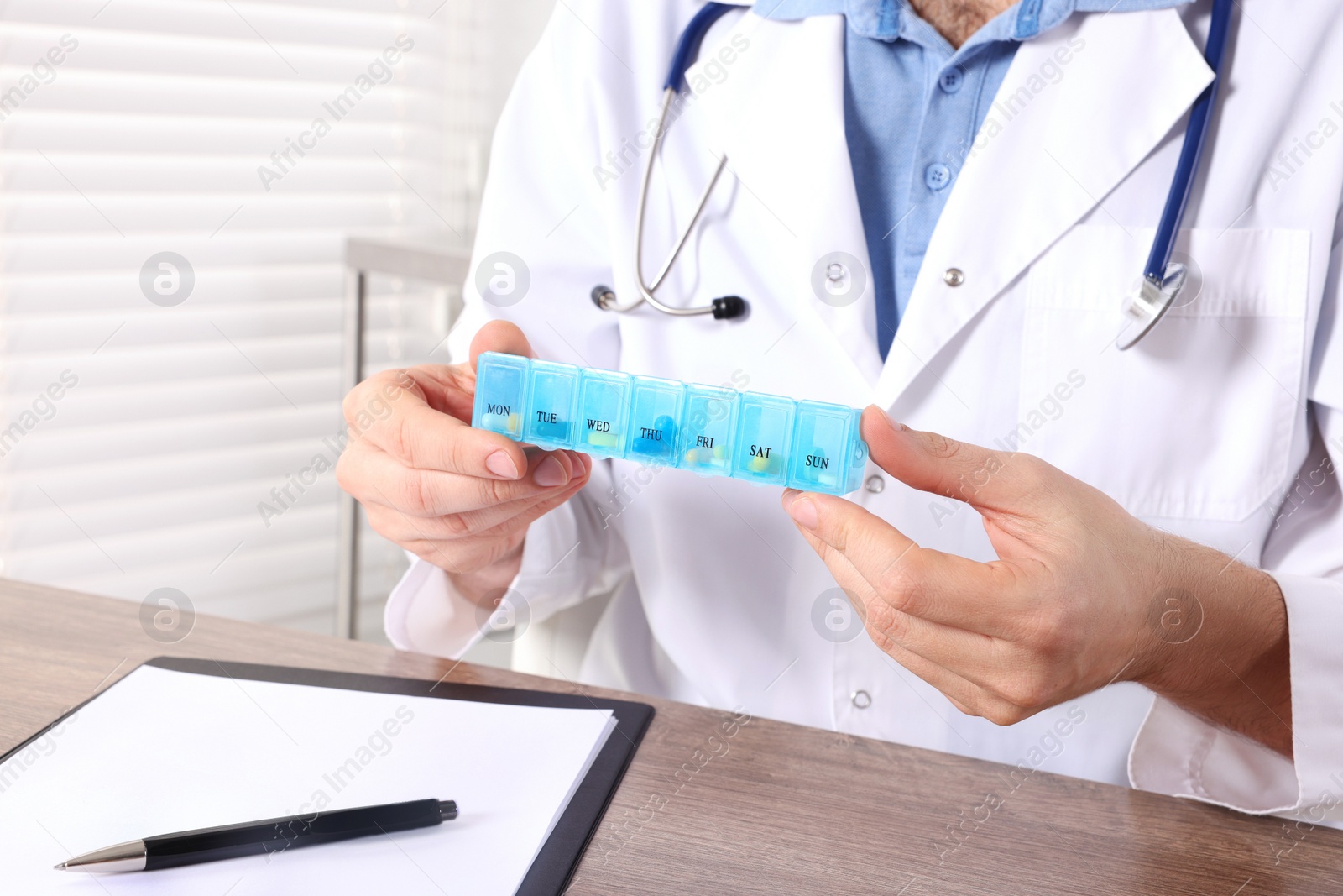 Photo of Doctor holding box of pills in clinic, closeup. Patient consultation