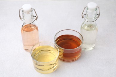 Photo of Different types of vinegar on light table, closeup