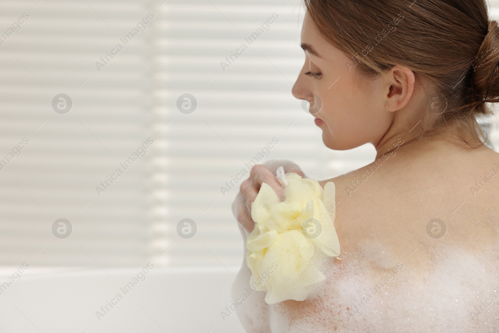 Photo of Woman taking bath with shower gel in bathroom, space for text