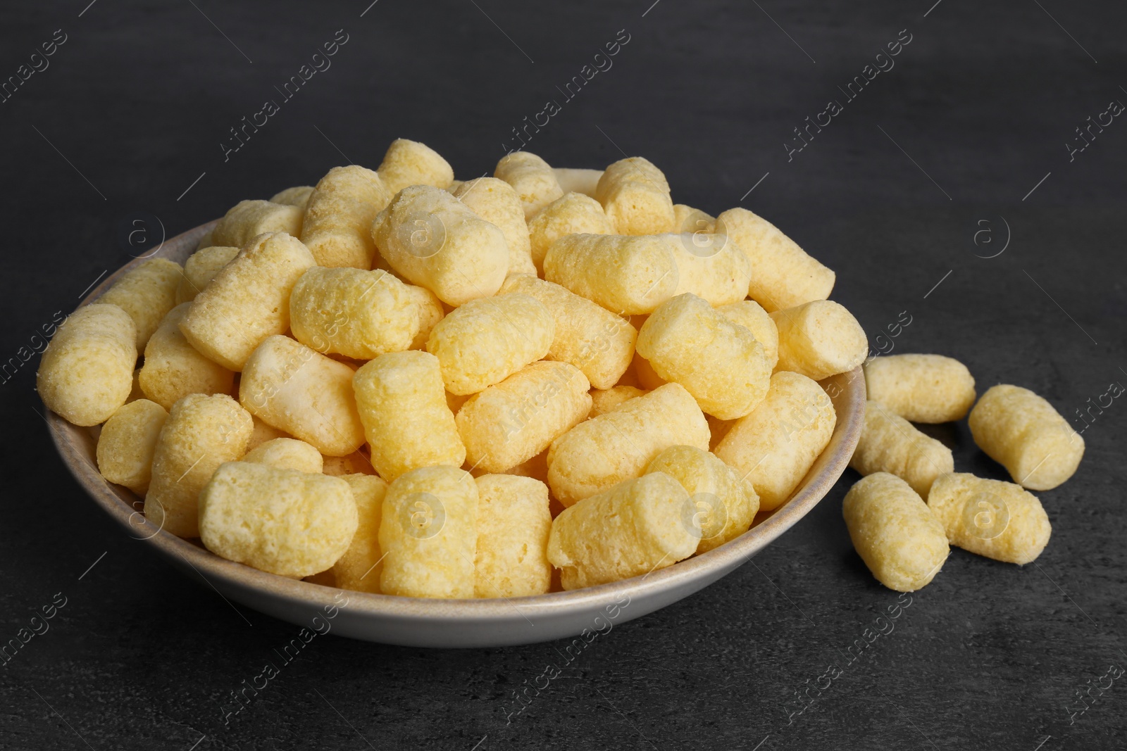 Photo of Plate of corn sticks on dark grey table