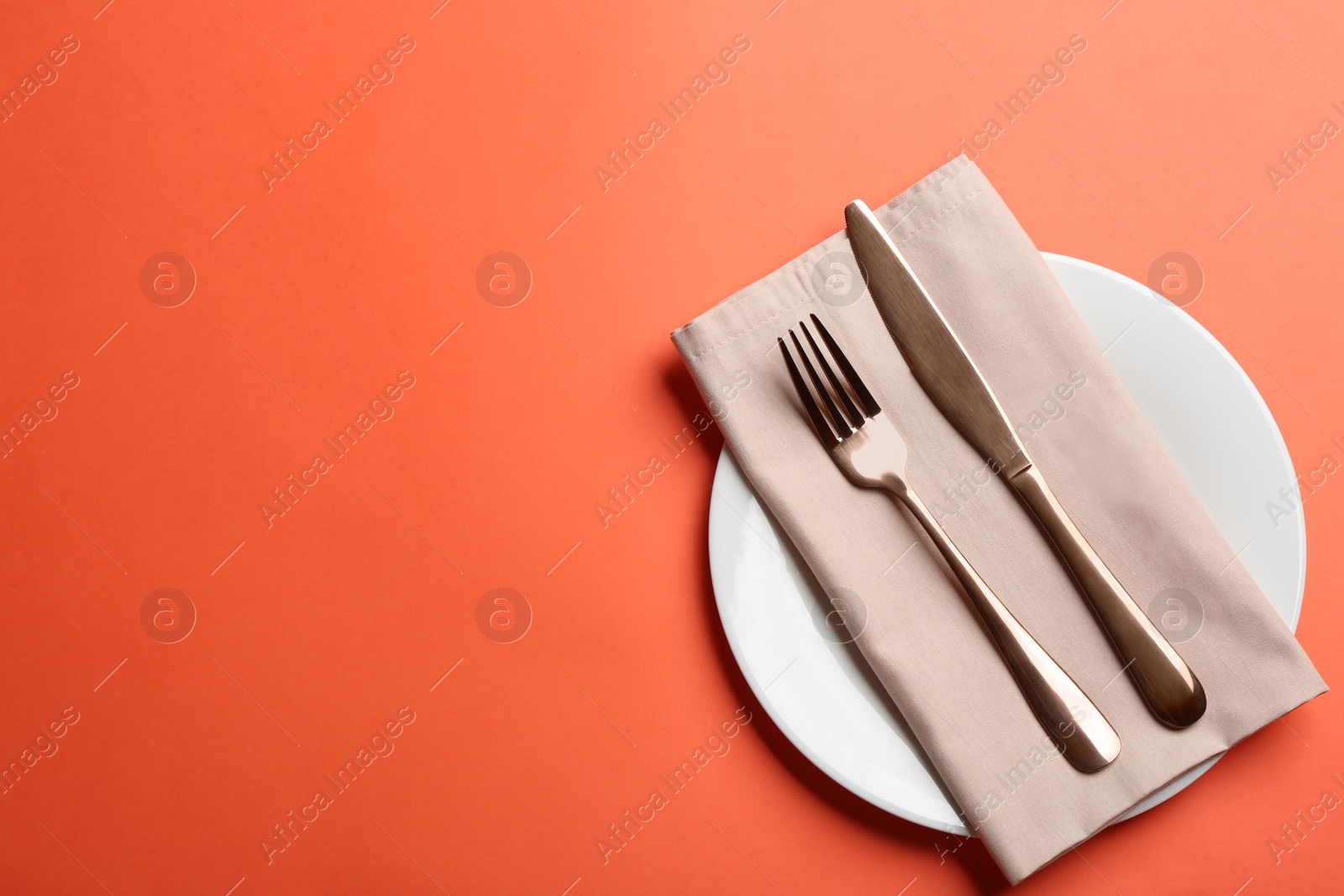 Photo of Elegant table setting on orange background, flat lay. Space for text