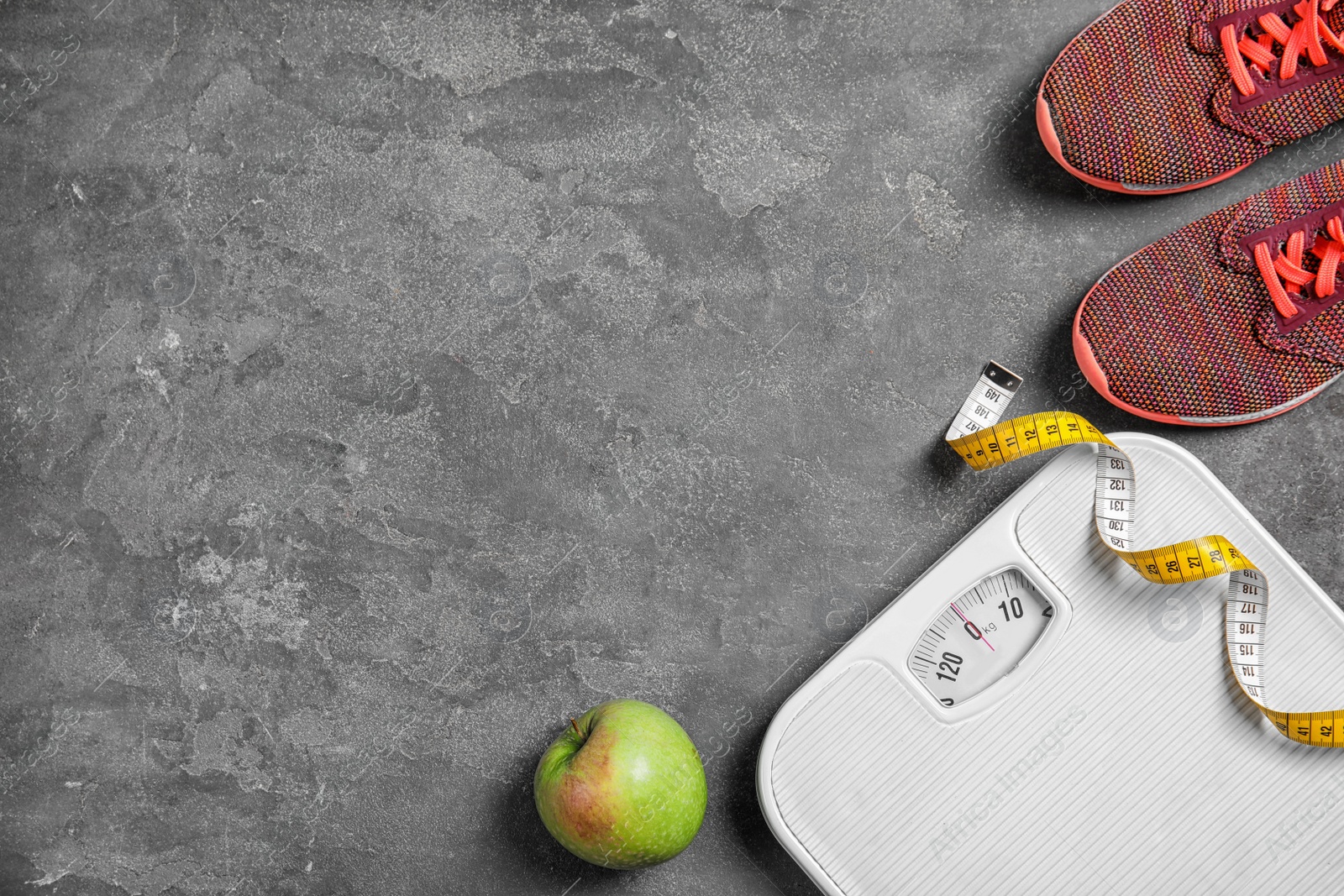 Photo of Flat lay composition with scales, measuring tape, sneakers and space for text on gray background. Weight loss