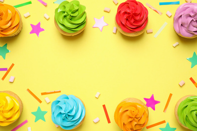 Colorful birthday cupcakes on yellow background, flat lay. Space for text