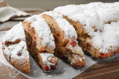 Photo of Traditional Christmas Stollen with icing sugar on wooden board