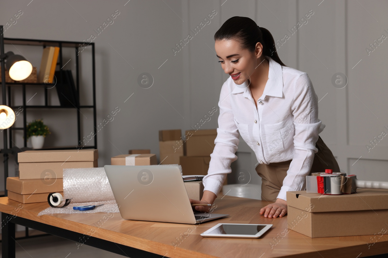 Photo of Seller working with laptop in office. Online store