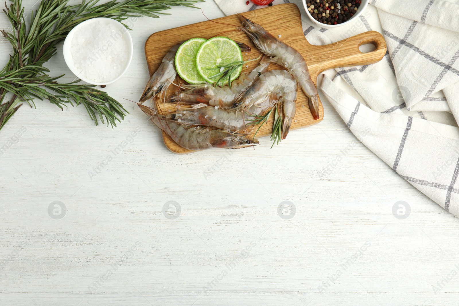 Photo of Flat lay composition with raw shrimps on white wooden table. Space for text