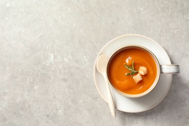 Photo of Tasty sweet potato soup served in mug on grey background, flat lay. Space for text