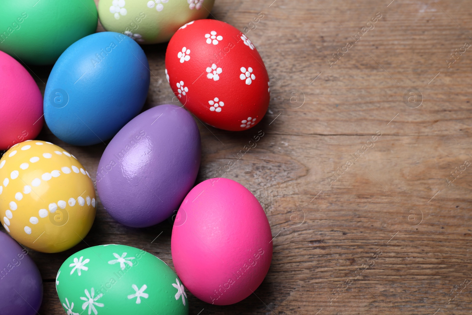Photo of Colorful eggs on wooden background, flat lay with space for text. Happy Easter
