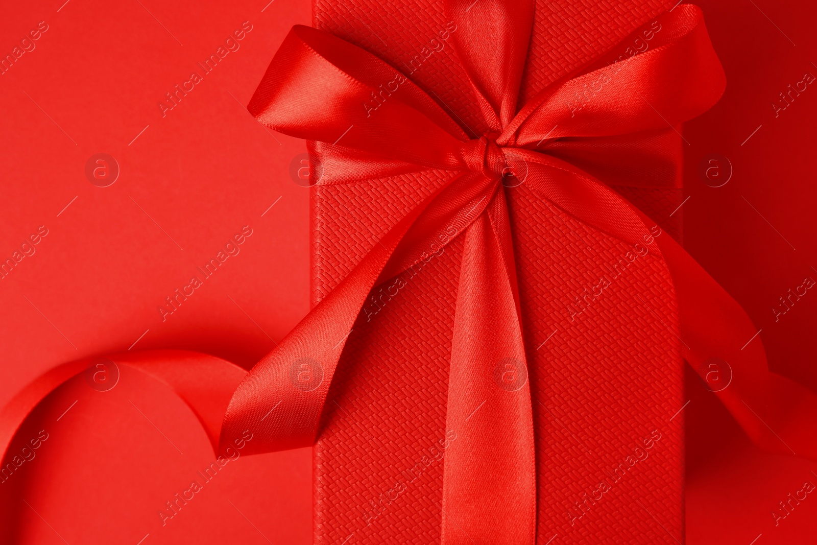 Photo of Beautiful gift box with bow on red background, top view