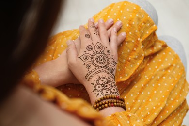 Photo of Woman with beautiful henna tattoo on hand, above view. Traditional mehndi