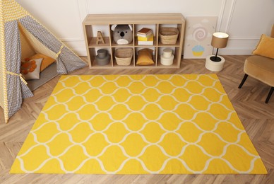 Photo of Modern children's room interior with yellow carpet and stylish furniture